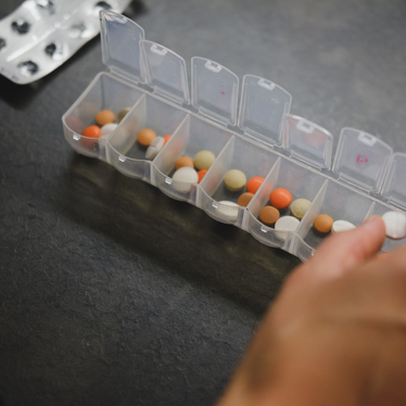 image of woman with her 7-day pill box.